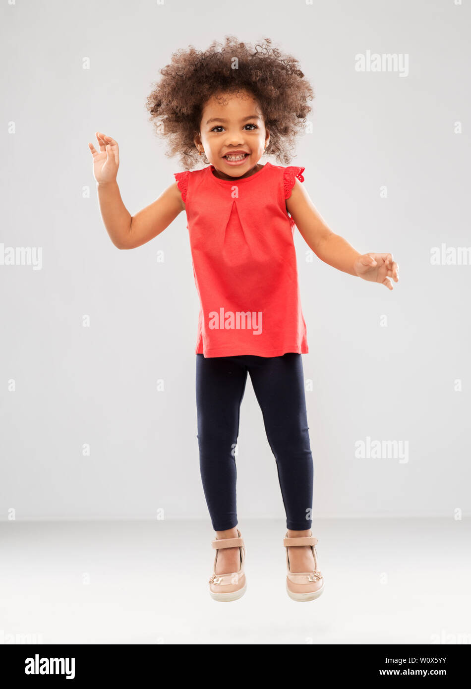 happy little african american girl jumping Stock Photo - Alamy
