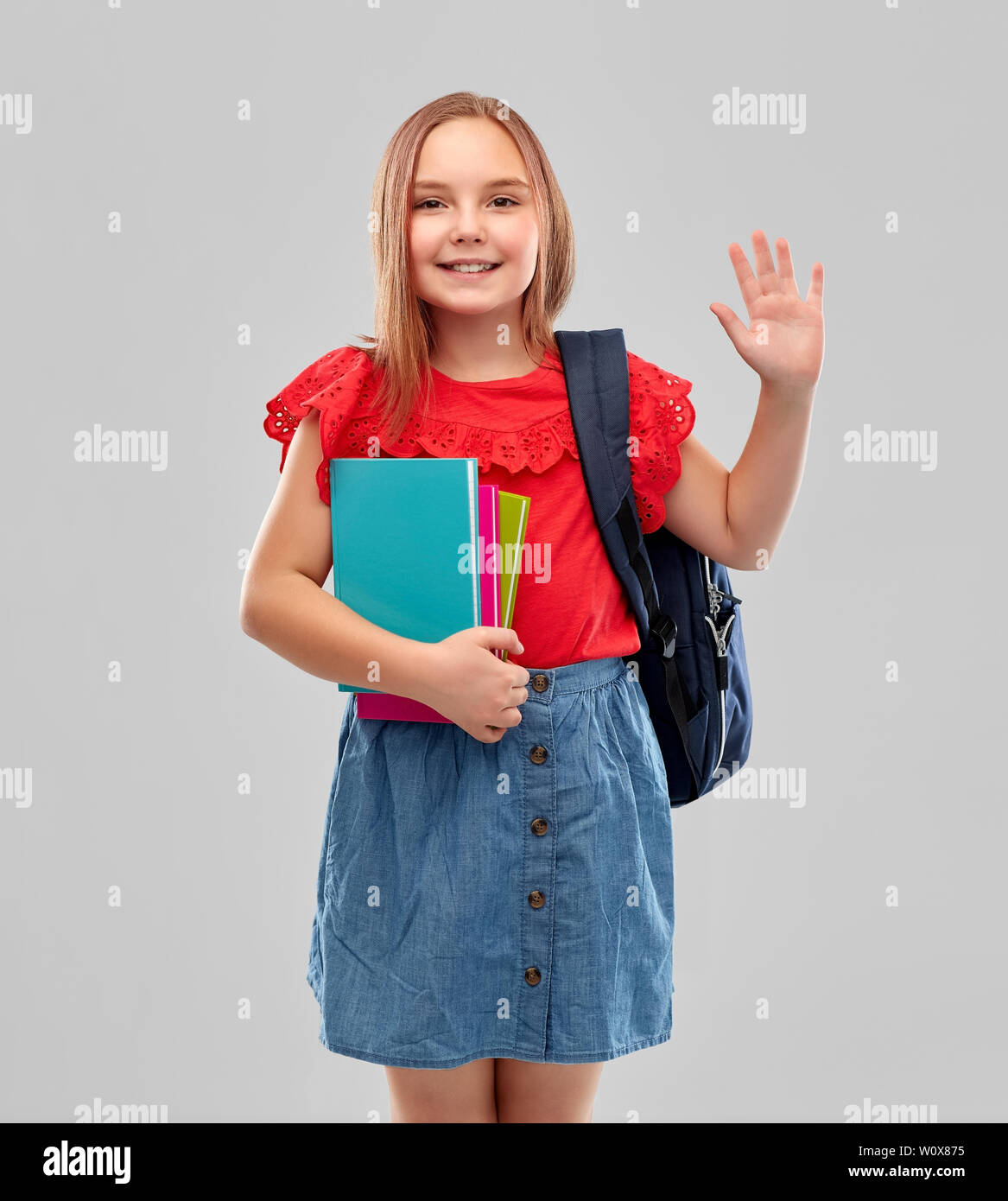 happy student girl with books and bag waving hand Stock Photo - Alamy