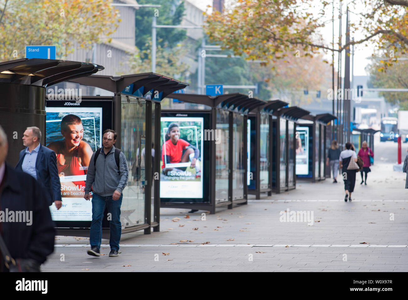 Commuters walk past multiple bu stops on York Street in Sydney on a cool Autumn morning in Australia Stock Photo