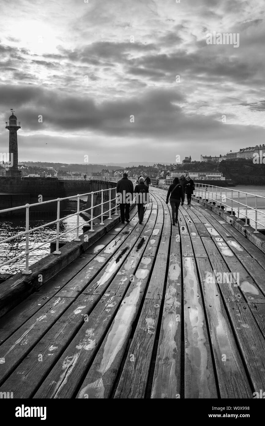 Whitby Harbour Harbour Wall Wooden Bridge shot in black and white on an overcast winters day Stock Photo