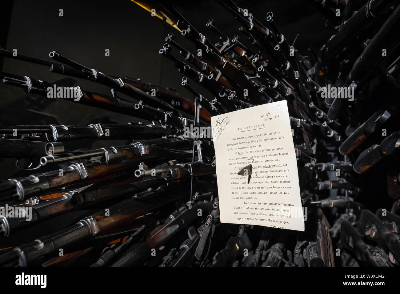 Display of German WWII rifles and a notification of occupation document issued at the outset of the Nazi takeover of Norway, Resistance Museum Oslo. Stock Photo