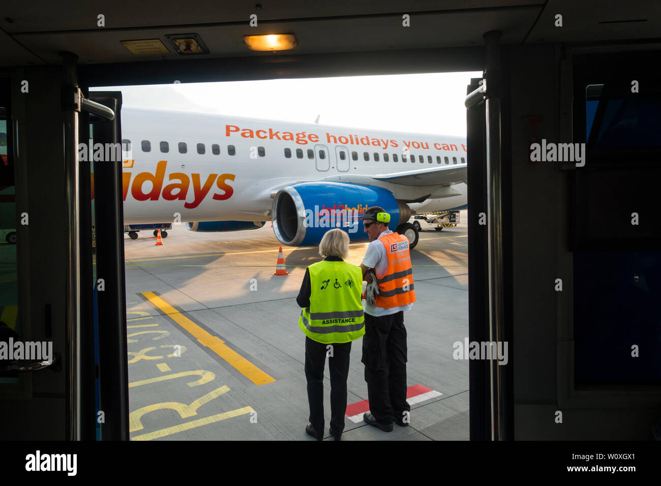 Ground staff at Krakow-Balice John Paul ii International Airport watch as passengers arrive, Krakow, Poland, Europe. Stock Photo