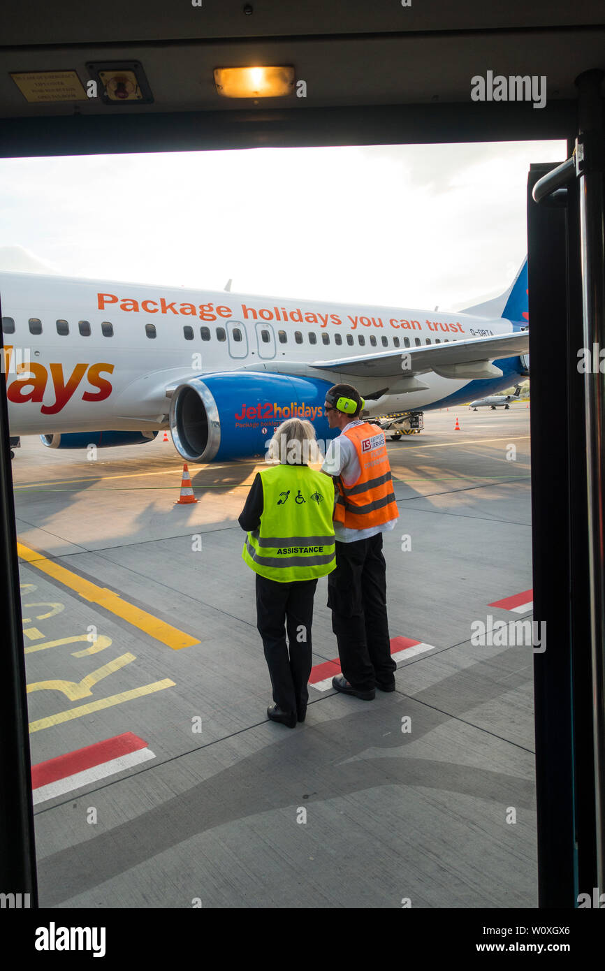 Ground staff at Krakow-Balice John Paul ii International Airport watch as passengers arrive, Krakow, Poland, Europe. Stock Photo