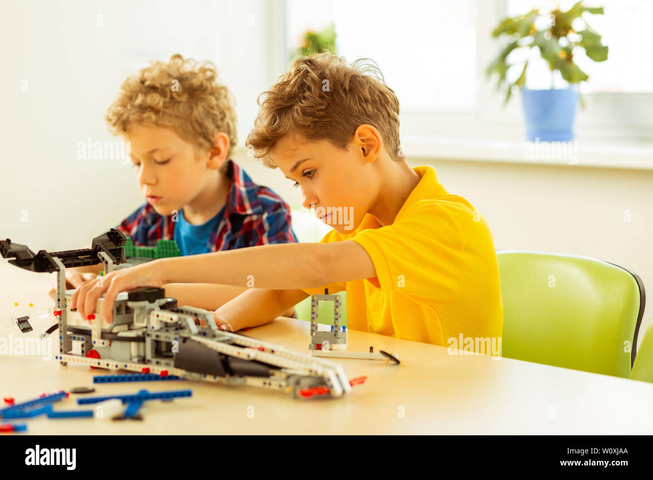 Diligent pupils. Nice serious boys being focused on their work while preparing an engineering project Stock Photo