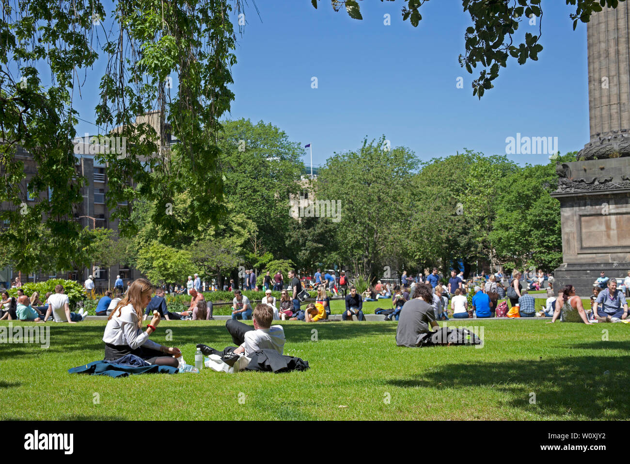 St Andrews Square Edinburgh, Scotland. 28th June 2019. Full sunshine in the city being enjoyed by office workers and visitors, 14 degrees in the morning with cool  wind increasing to 17 degrees in the afternoon allowing a relaxing lunch hour sunbathe. Stock Photo