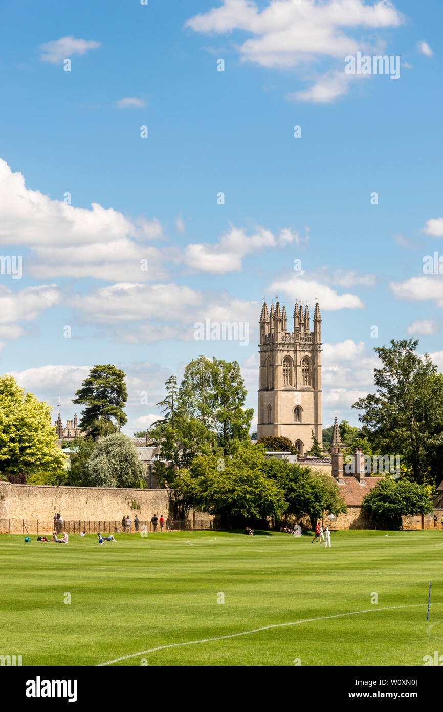 Brightly sunlit Magdalen Tower seen across Christ Church Meadows playing fields on a beautiful summer's day in the famous university town of Oxford. Stock Photo