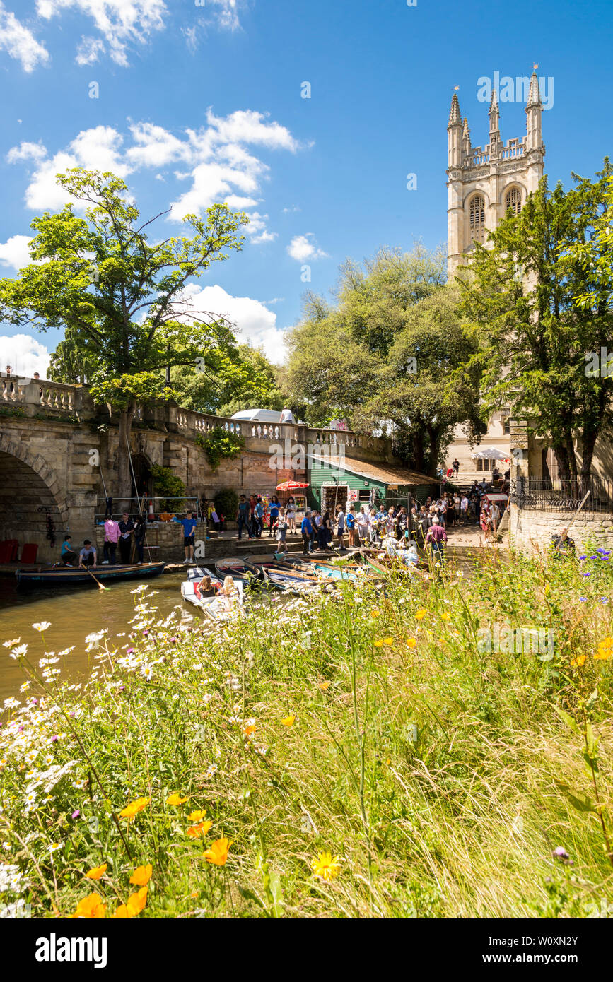 Magdalen bridge and tower are the backdrop for people hiring boats and punts on the river Cherwell on a beautiful sunny afternoon in Oxford. Stock Photo