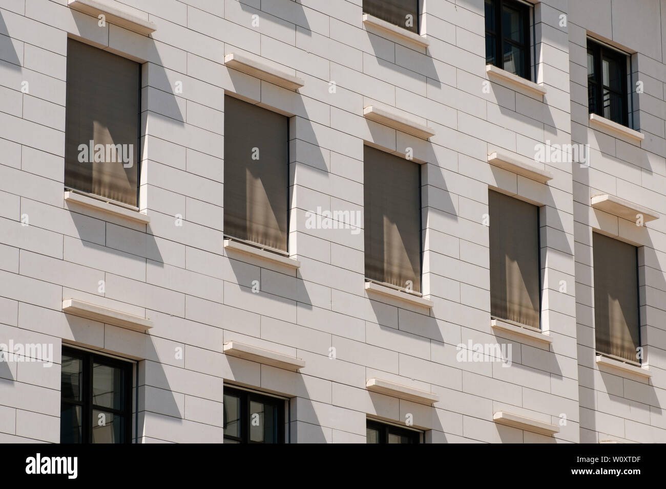 windows building facade with closed shutters / sun blinds - Stock Photo