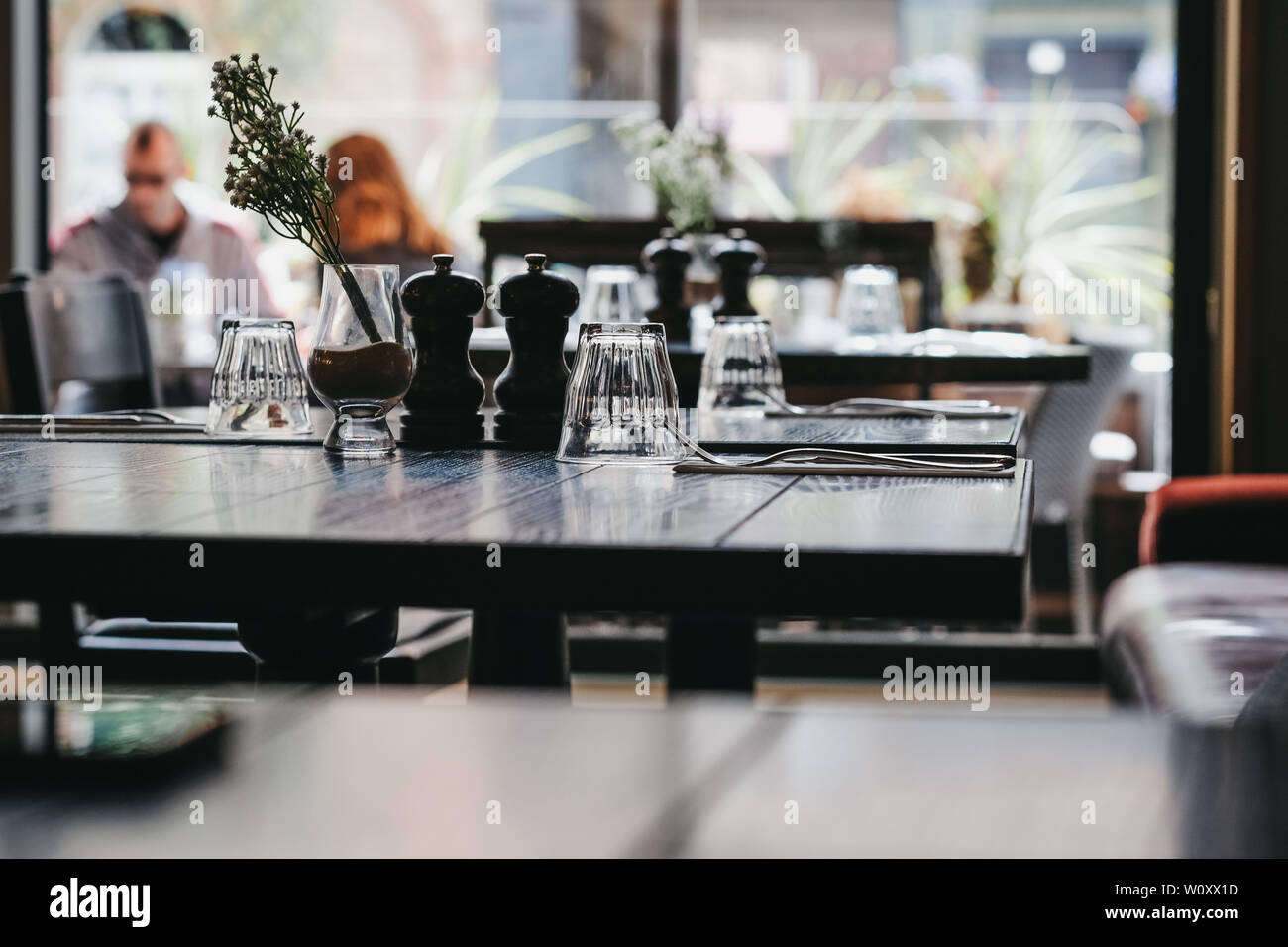 Table set inside a restaurant, selective focus, natural light, windows on the background. Stock Photo