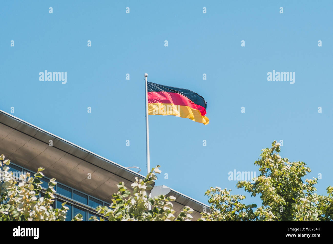 german flag on pole on building - national flag of Germany Stock Photo