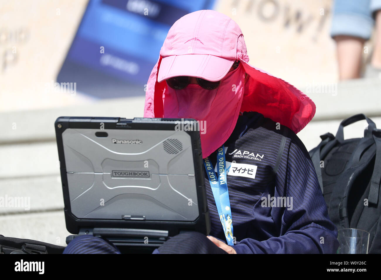 Hamburg, Germany. 28th June, 2019. Beach volleyball, World Cup, Rothenbaum Stadium: A journalist from Japan protects herself from the sun during a game on Court 2. Credit: Christian Charisius/dpa/Alamy Live News Stock Photo