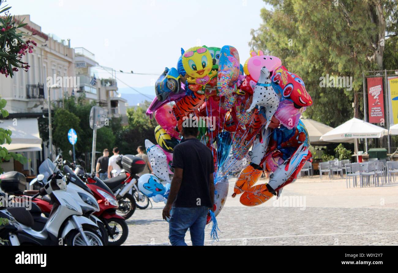 a man selling cartoon helium balloons on the street in athens greece Stock Photo