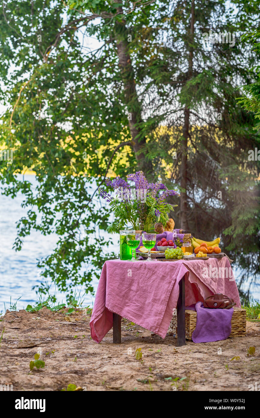 picnic near water at table with flowers in forest different kind of ...