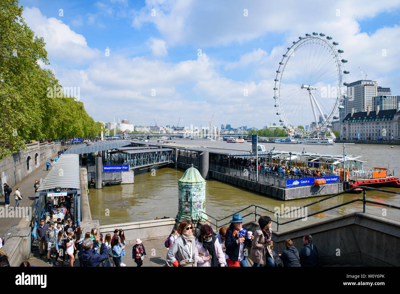 Westminster Millennium Pier on the north bank of the River Thames with London Eye at background in London, United Kingdom Stock Photo