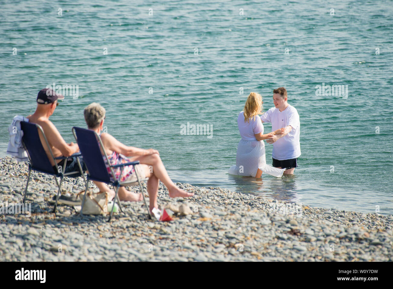 Aberystwyth, Wales, UK. 28th Jun 2019. UK weather: People at the seaside in Aberystwyth enjoying a day of unbroken blue skies and hot sunshine. The country is heading towards the hottest day of the year so far as a plume of scorching hot air drifts in from the continent.   Photo Credit: keith morris/Alamy Live News Stock Photo