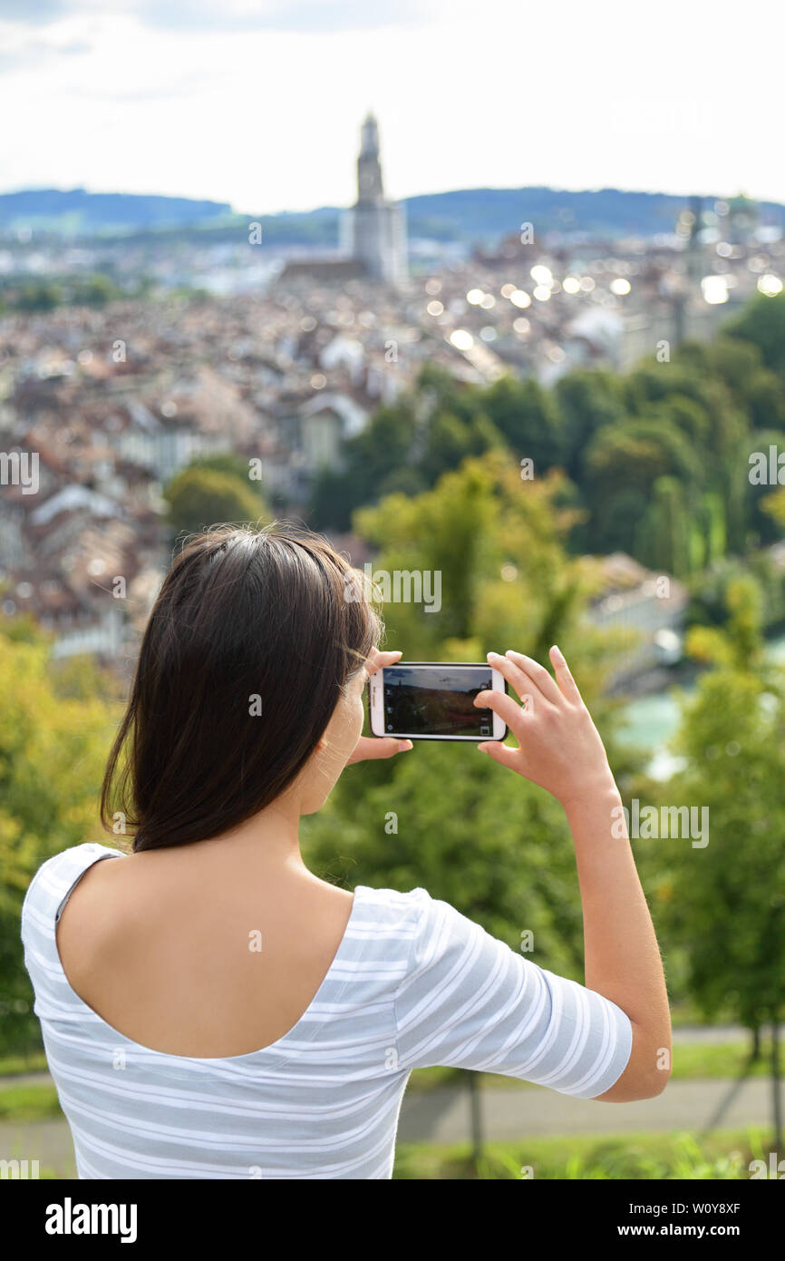 Tourist with smartphone camera in Bern, Switzerland at Rosengarten, the Rose Garden view. Woman taking photograph with smartphone at enjoying view of Berne landmarks and tourist attractions. Stock Photo