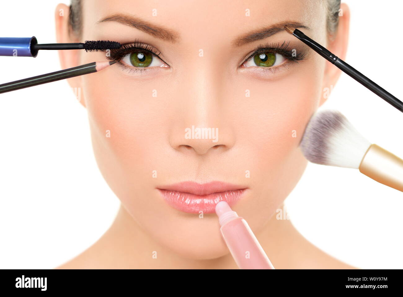 Makeup concept - Asian woman with many brushes against beauty face putting  mascara, blush and lip gloss Stock Photo - Alamy