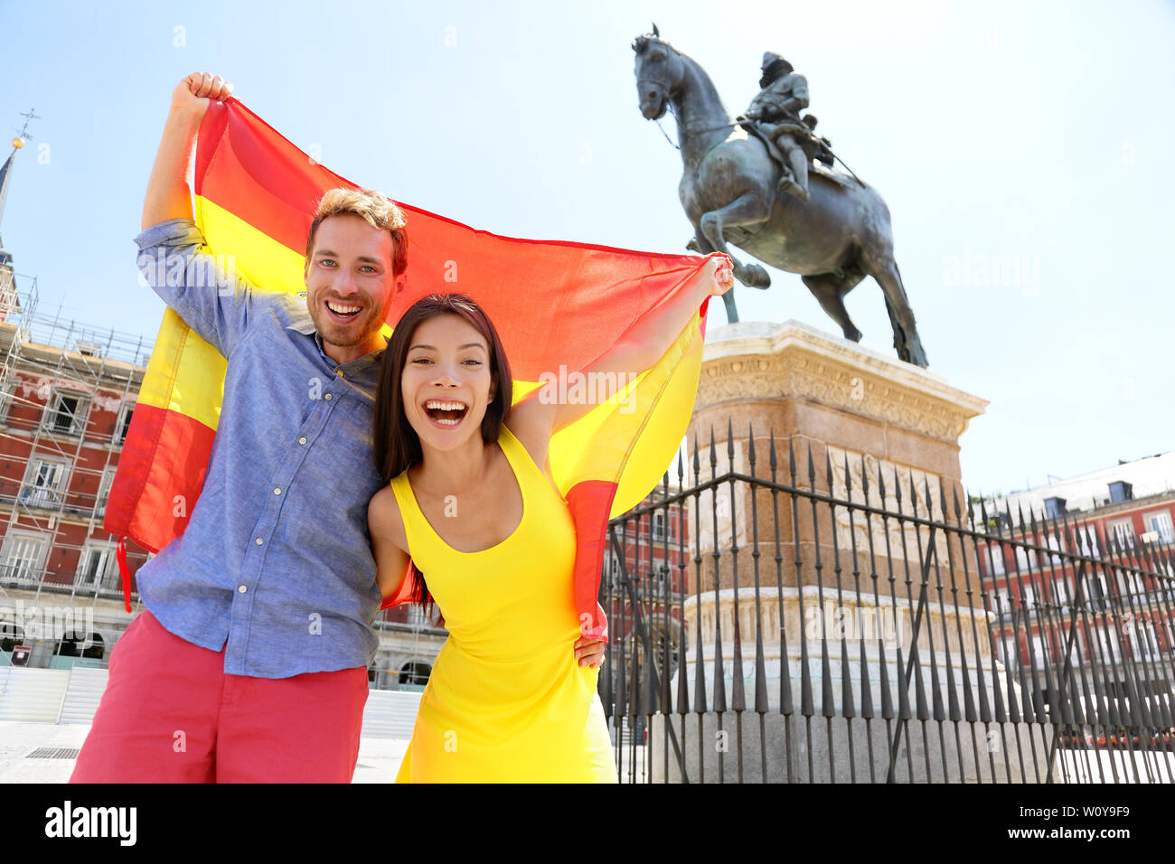 Madrid people showing Spain flag on Plaza Mayor cheerful and happy in