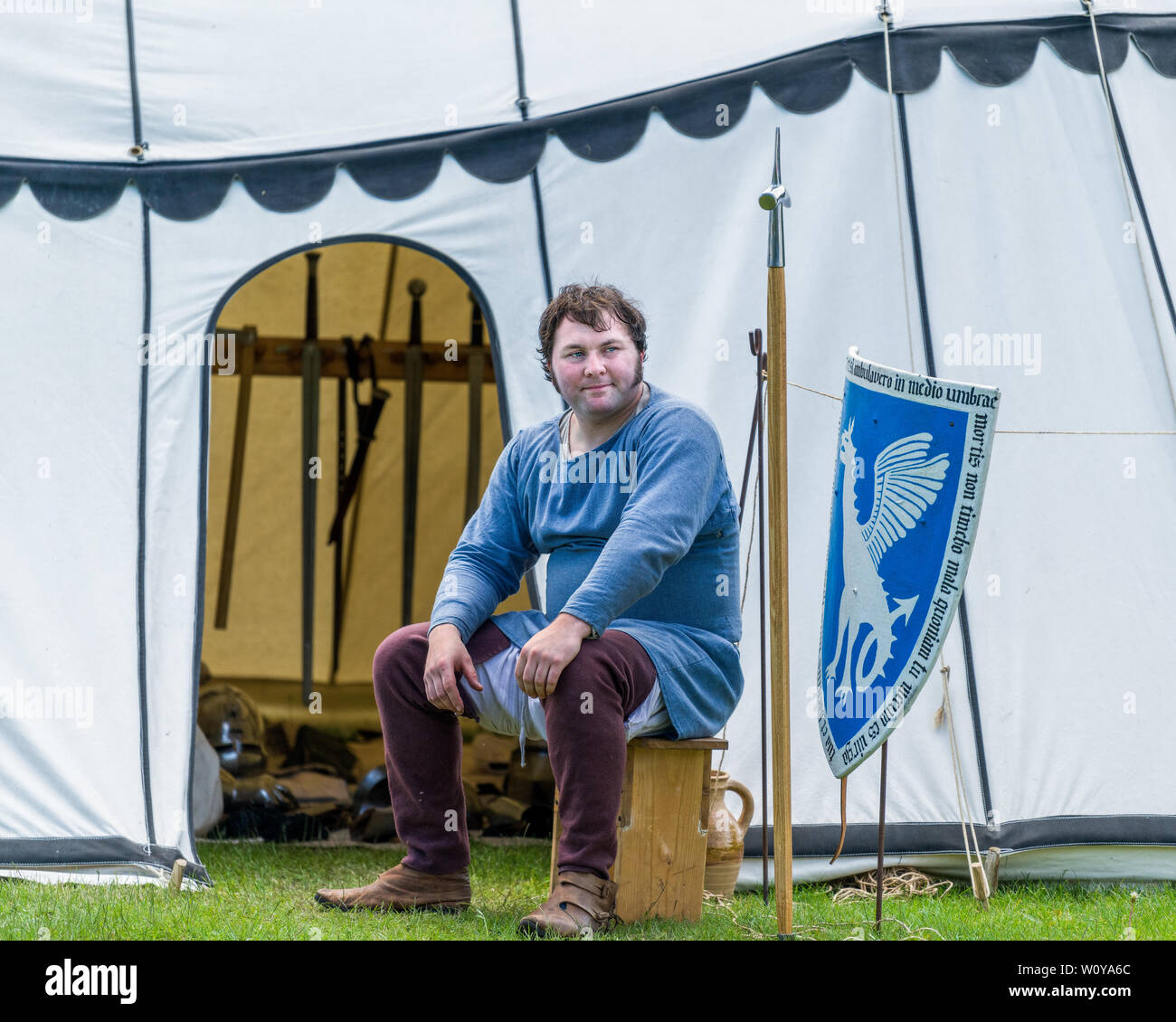 A medieval armorer sits outside his tent. The encampment at Cardiff Joust 2019. Stock Photo
