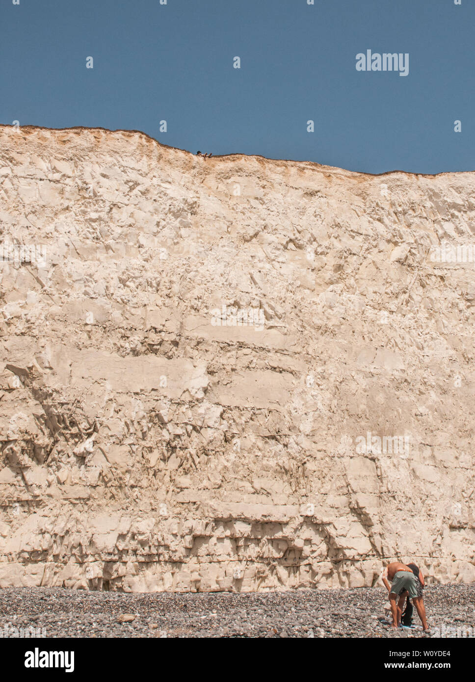 Birling Gap, Eastbourne, East Sussex. 28 June 2019. UK Weather:Look carefully. Top of cliff, feet over edge .Some seem unaware of the fragility & undercutting along the chalk cliffs. Rock falls occuring frequently. It is not safe on the edge. Please keep safe. . Stock Photo