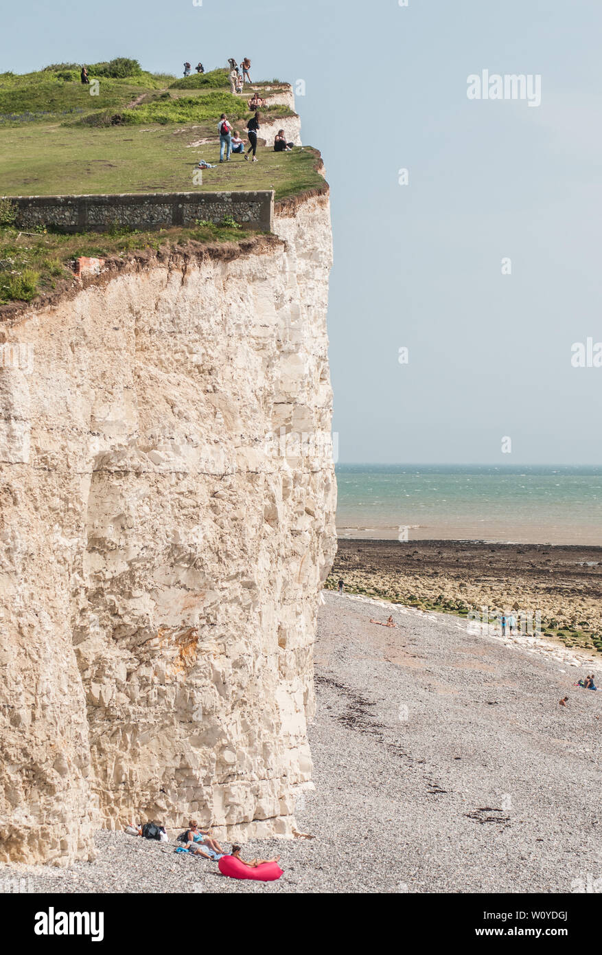 Birling Gap, Eastbourne, East Sussex. 28 June 2019. UK Weather:Glorious summer weather is bringing tourists flocking to the South Coast beauty spot. Some seem unaware of the fragility & undercutting along the chalk cliffs. Rock falls occuring frequently. It is not safe on the edge. Please keep safe. . Stock Photo