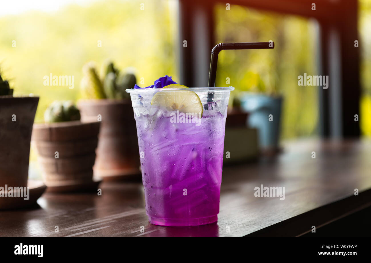 Ice and cold sweet soda drink with window low sun lighting. Stock Photo