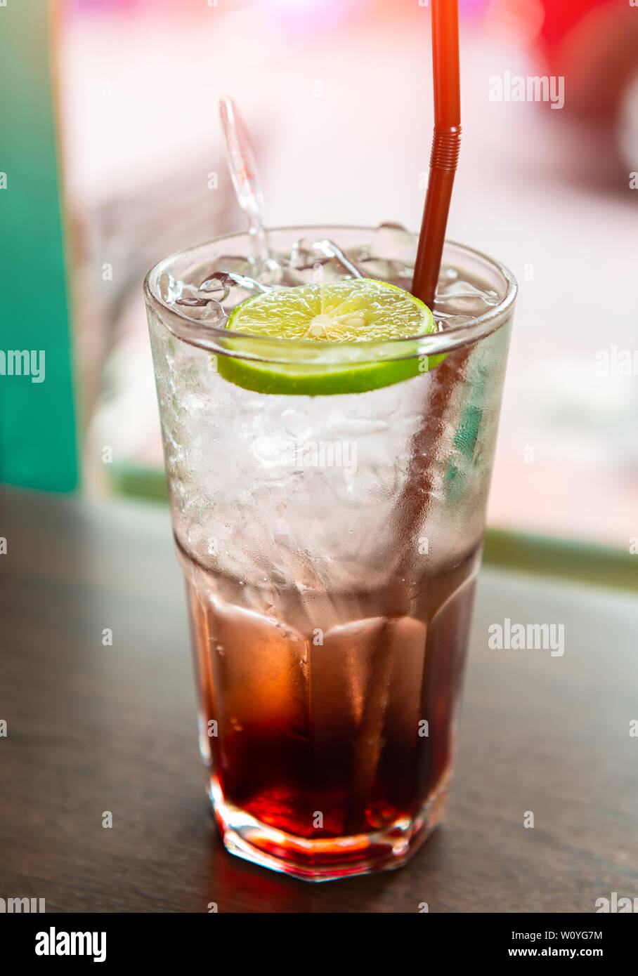 Ice and cold sweet soda drink with window low sun lighting. Stock Photo