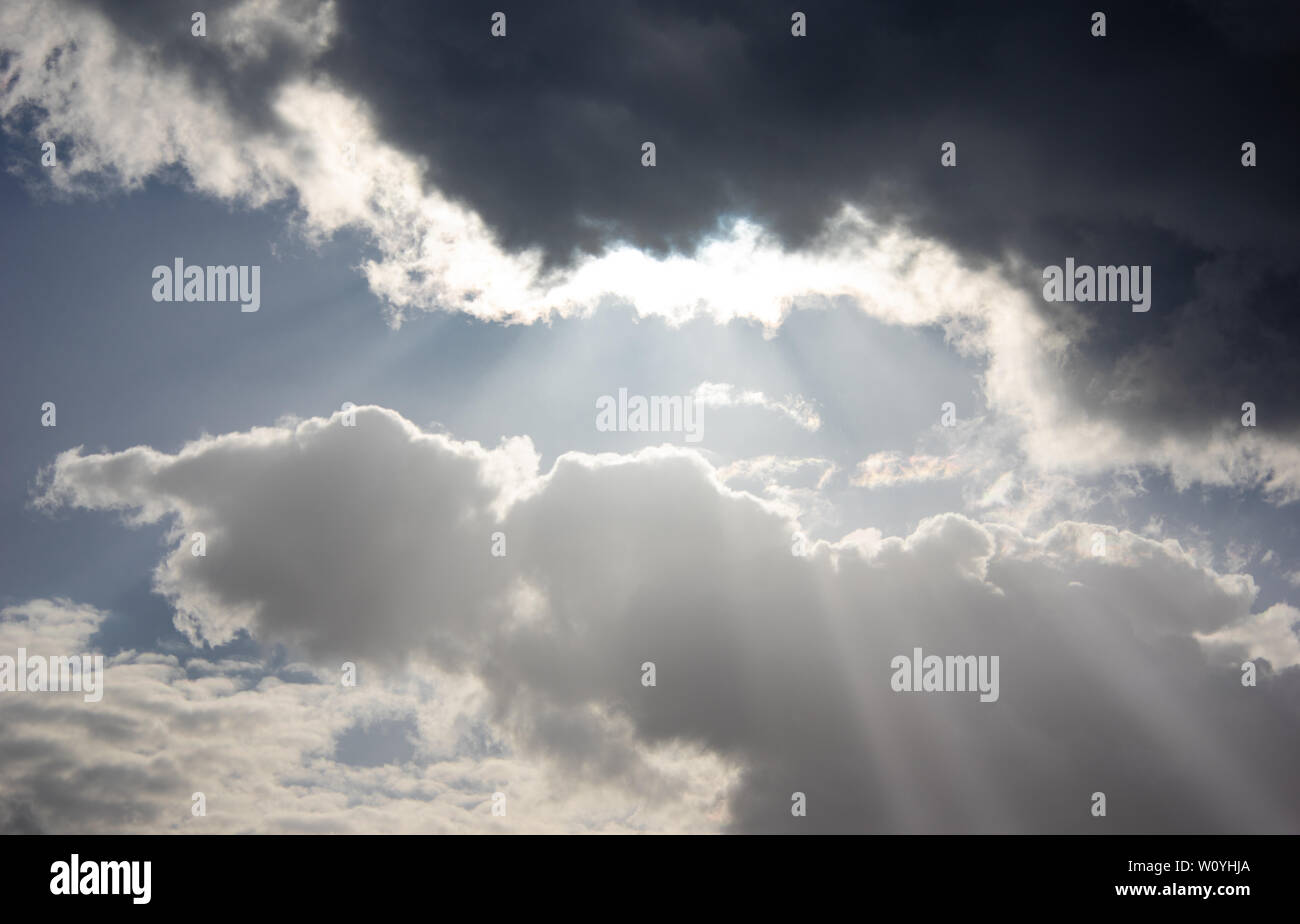 sunrays breaking through storm clouds Stock Photo