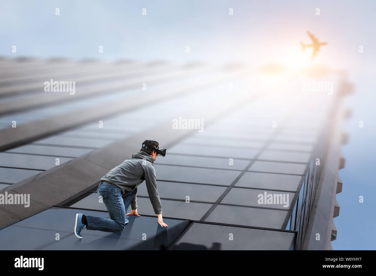 Young man in VR glasses on start position, building facade background ...