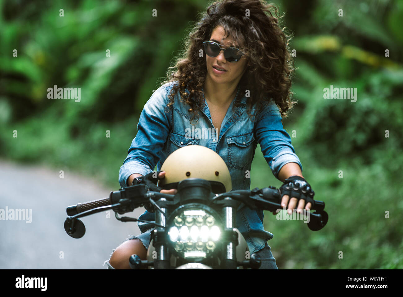 Beautiful female biker driving a cafe' racer motorbike - Pretty girl  driving a motorbike and enjoying the roadtrip Stock Photo - Alamy