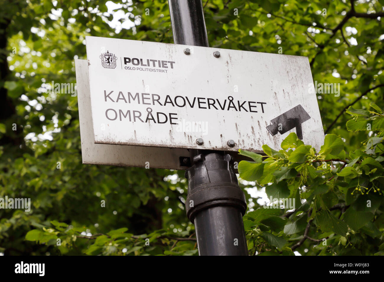 Oslo, Norway - June 20, 2019: Sign in Norwegian with information near the National thatre are camera-monitored area by the police department. Stock Photo