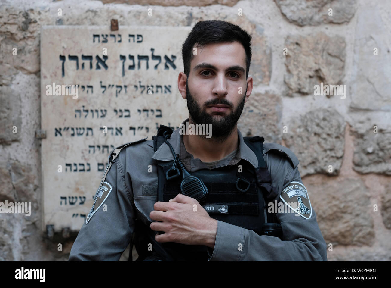 An Israeli border policeman stands guard in front of a plaque in memory of Elhanan Aharon, a young Jewish student in the 'Ateret Cohanim' Yeshiva who was murdered by Palestinians in 1991 while walking on El Wad also called Hagai Street in the old city of Jerusalem. Israel Stock Photo