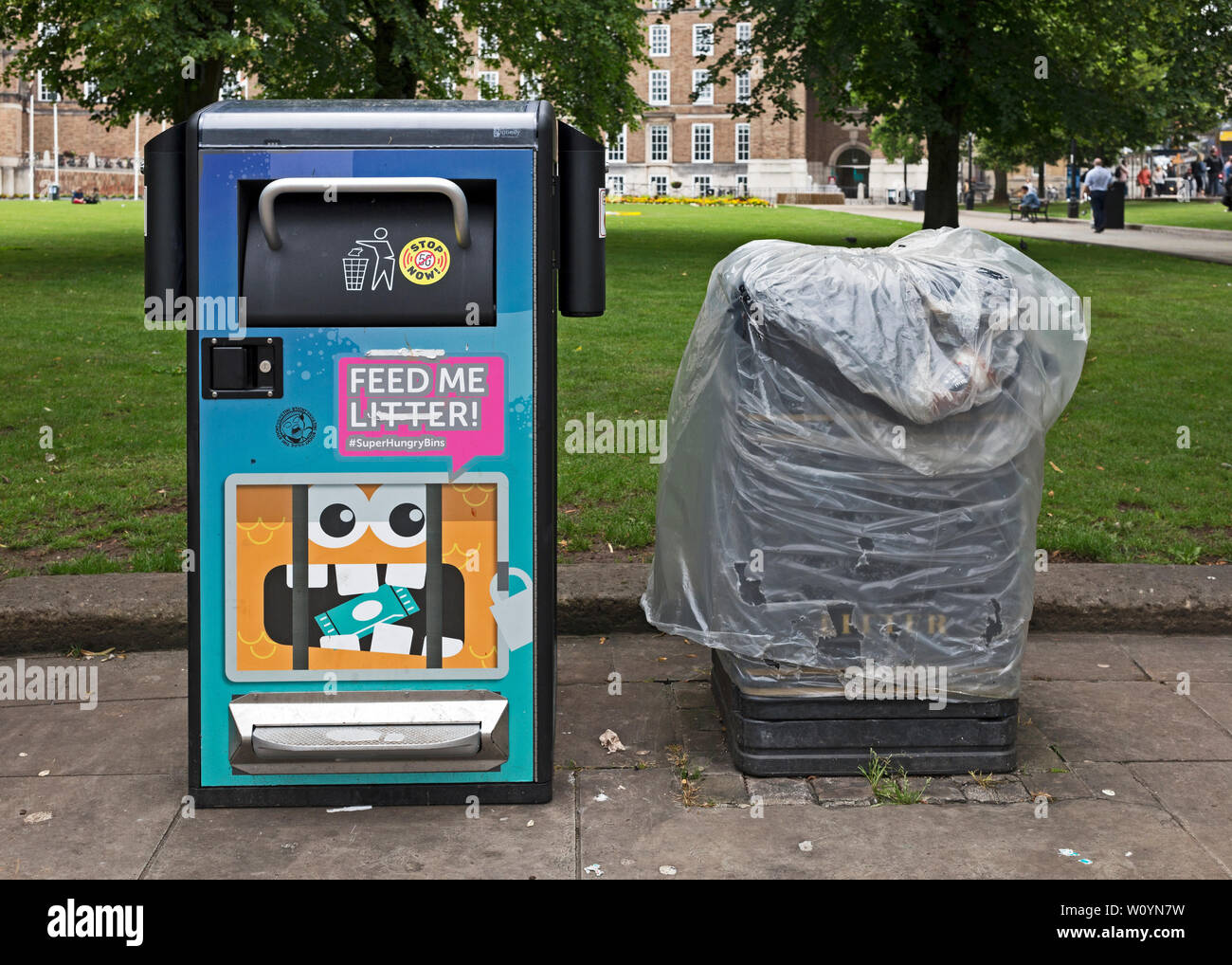 A new bin which compacts litter alongside one of the traditional bins which it has replaced on College Green in Bristol, UK. Stock Photo