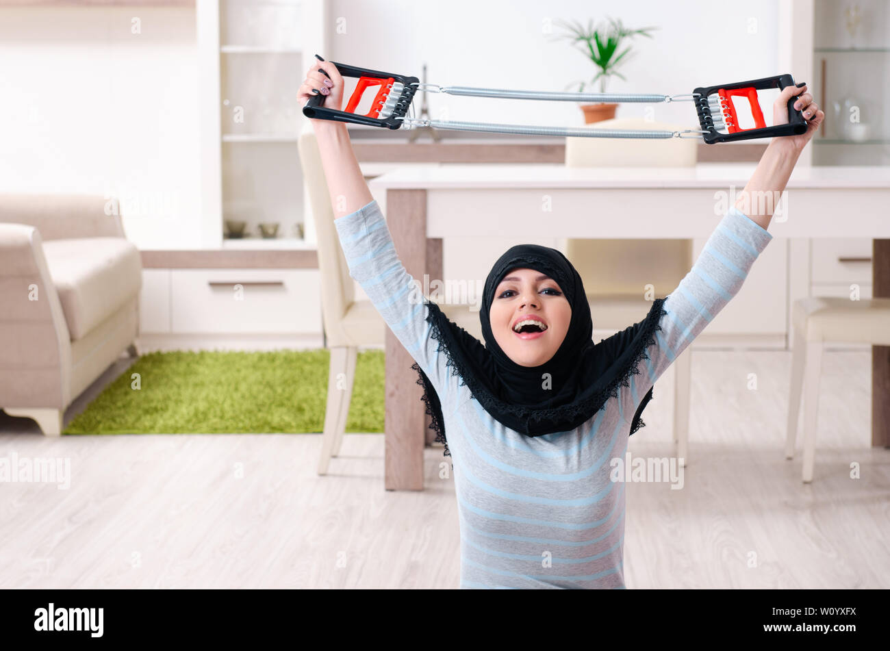 Young woman in hijab doing exercises at home Stock Photo - Alamy