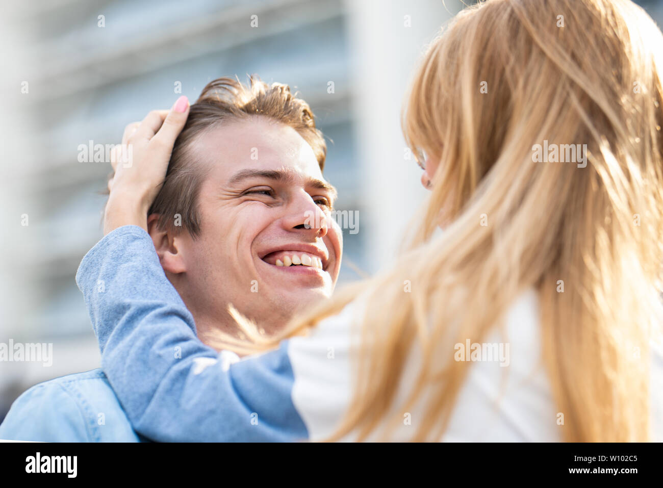 Happy to spending time together. Young beautiful couple outdoor fashion portrait. Attractive boy and girl hugging and kissing. Stock Photo