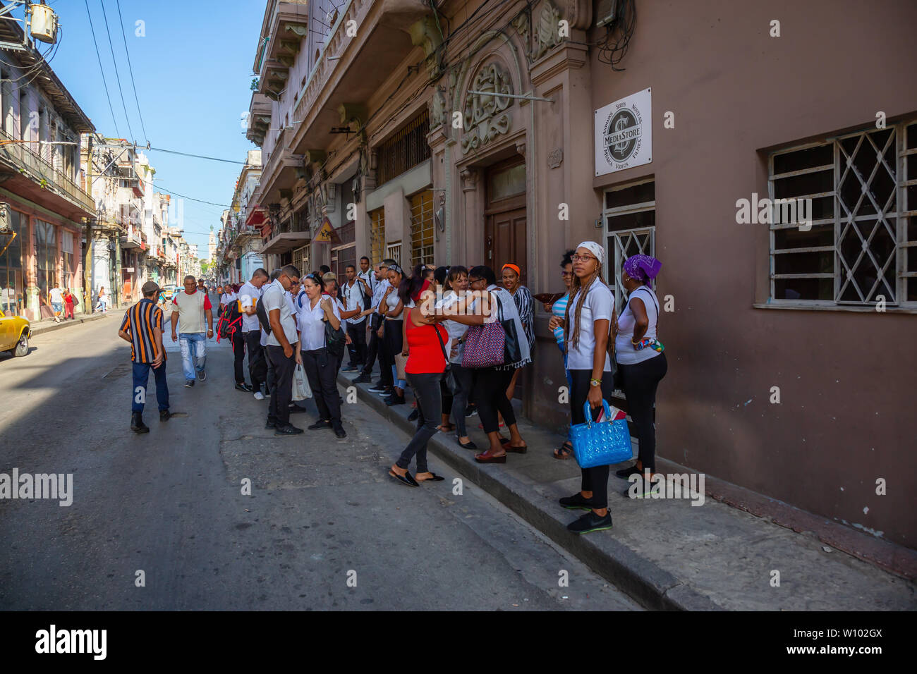 Havana, Cuba - May 13, 2019: Crowd of Cuban People waiting in line for the food in the streets of the Old Havana City during a bright sunny morning. Stock Photo