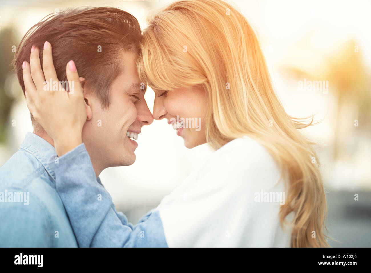 Beautiful couple in love dating outdoors and smiling. Beautiful girl embraces the guy Stock Photo