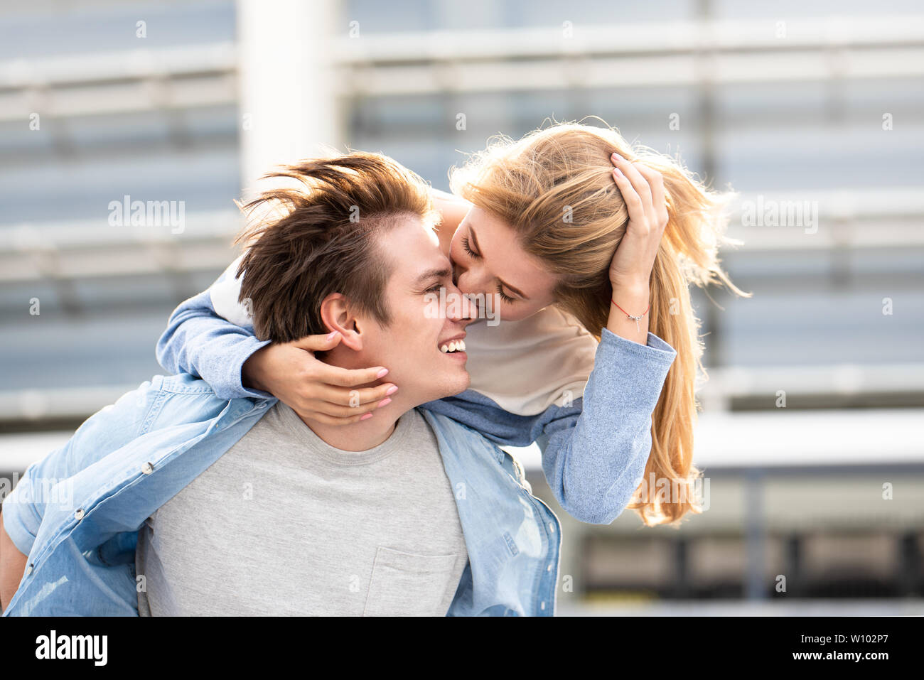 Happy to spending time together. Young beautiful couple outdoor fashion portrait. Attractive boy and girl hugging and kissing. Stock Photo