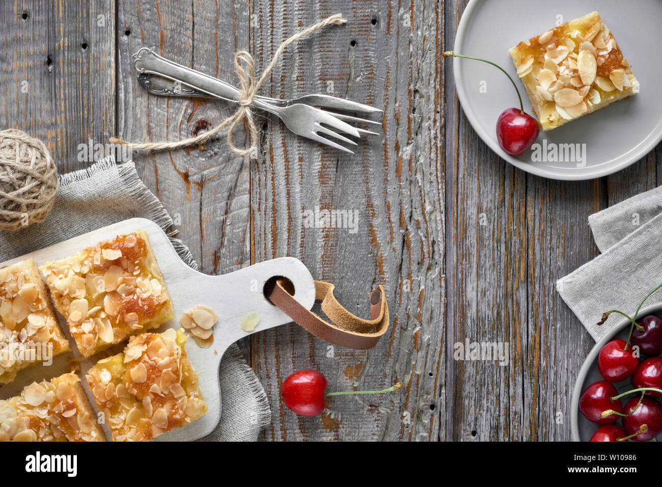 Almond cake cut into portions on a serving board, flat lay on rustic wooden table Stock Photo