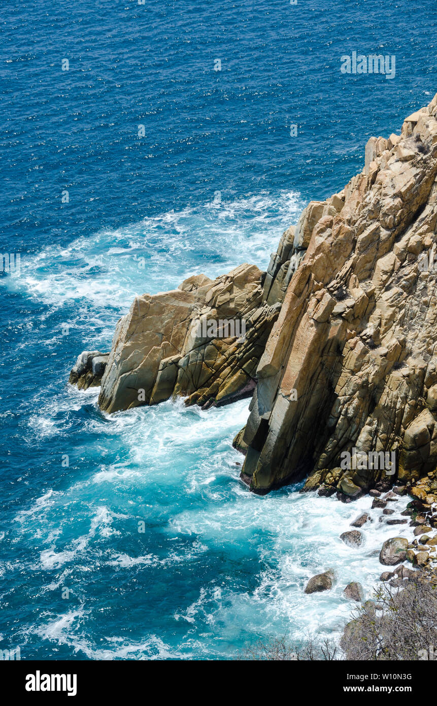 Blue sea with rocky shore in sunny afternoon, Acapulco, Mexico. Stock Photo