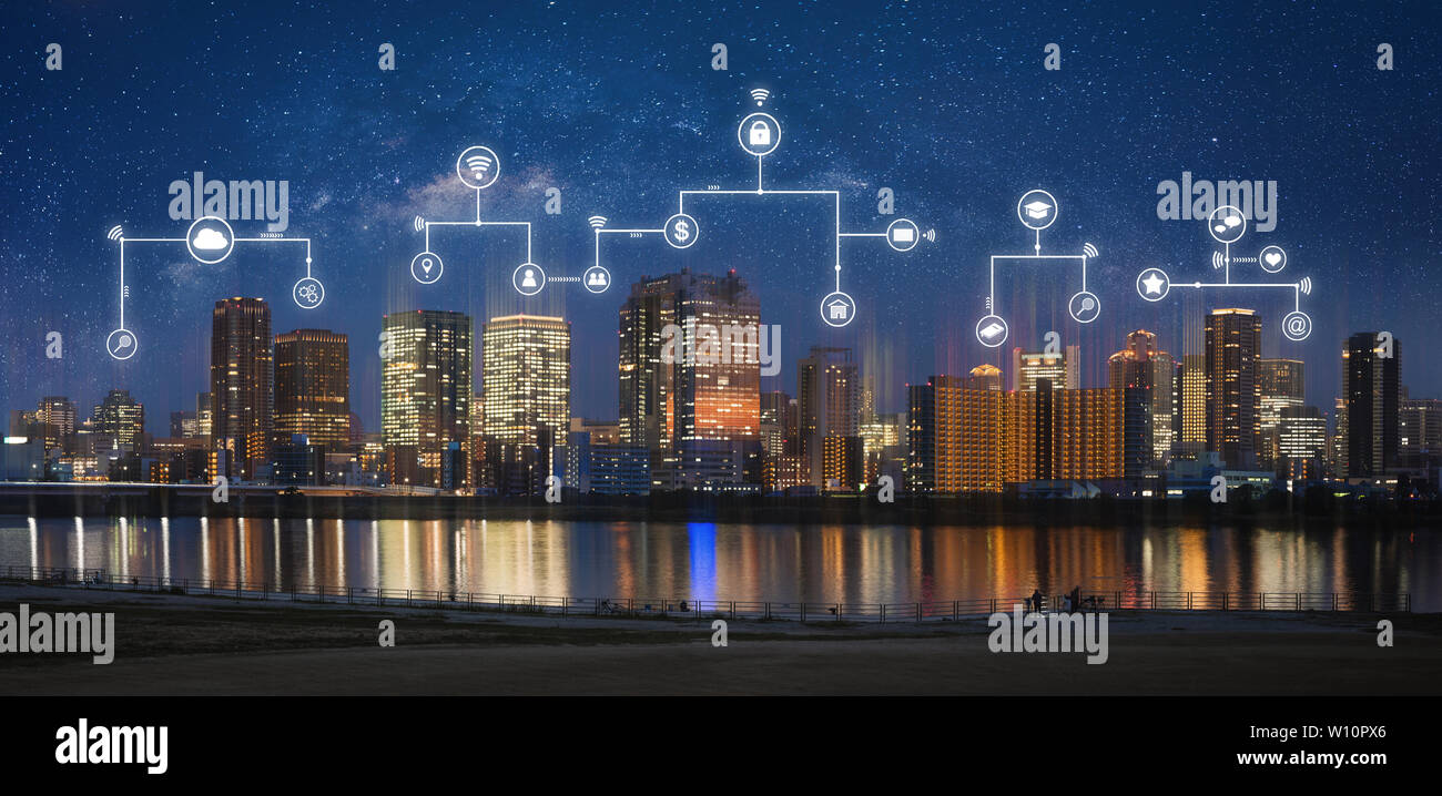 Smart city, internet wireless and networking in the city. Modern city at night with internet network and online media application icons Stock Photo