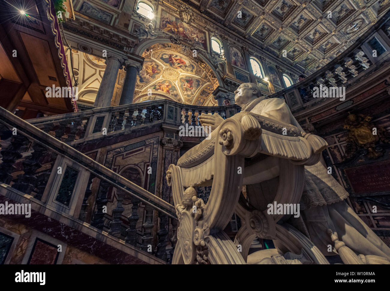At first glance at this image, we see a statue in the church, a sculpted saint, among many other religious signs and paintings specific to religion. B Stock Photo