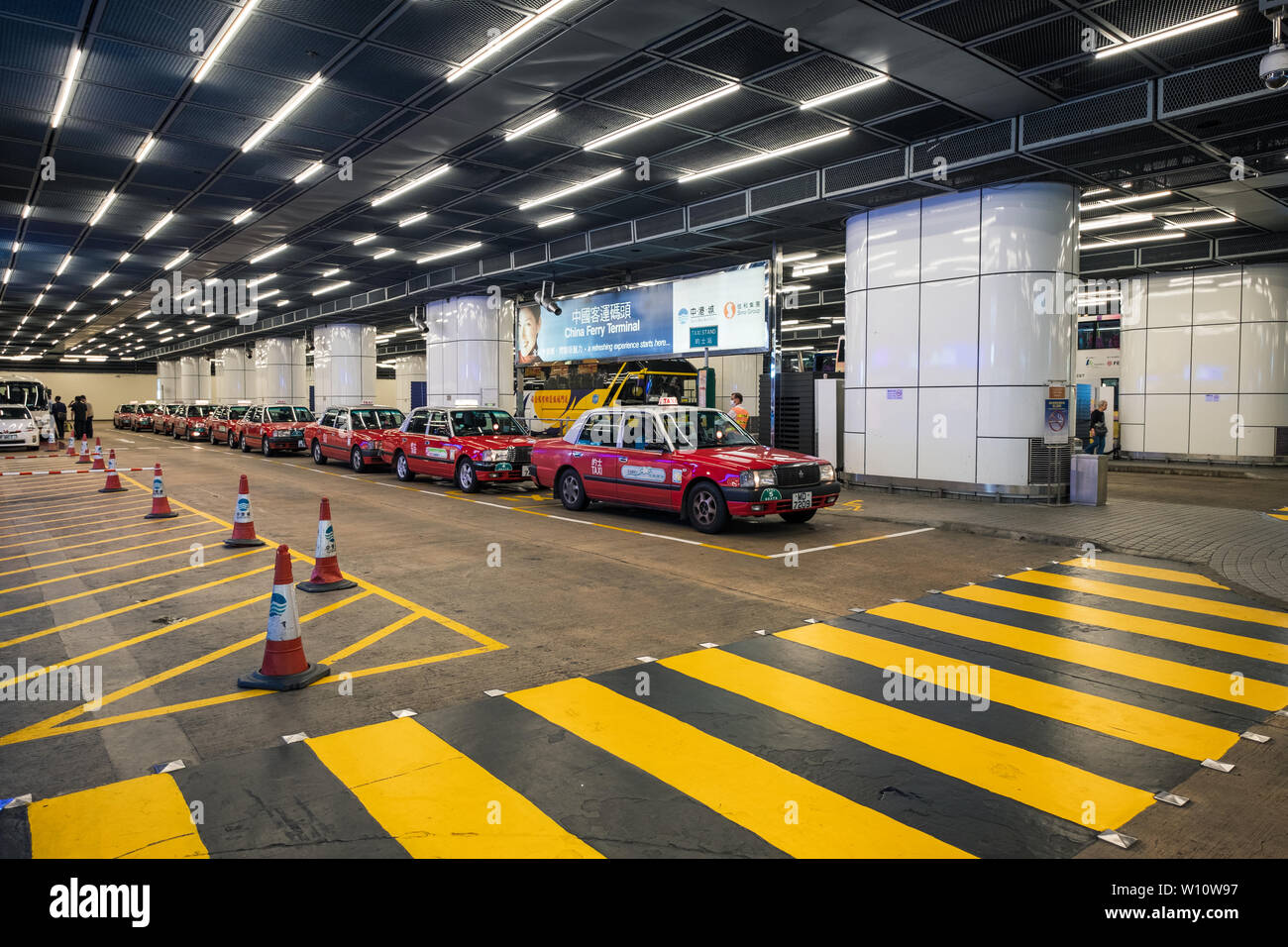 Hong Kong, China - May 06 2018 : Red retro taxi parked waiting passenger with sign across in the building Stock Photo