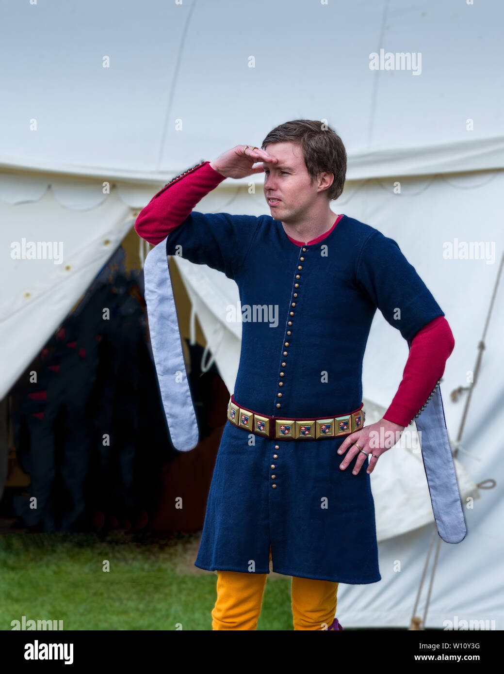 A medival squire surveys the camp. The encampment at Cardiff Joust 2019. Stock Photo