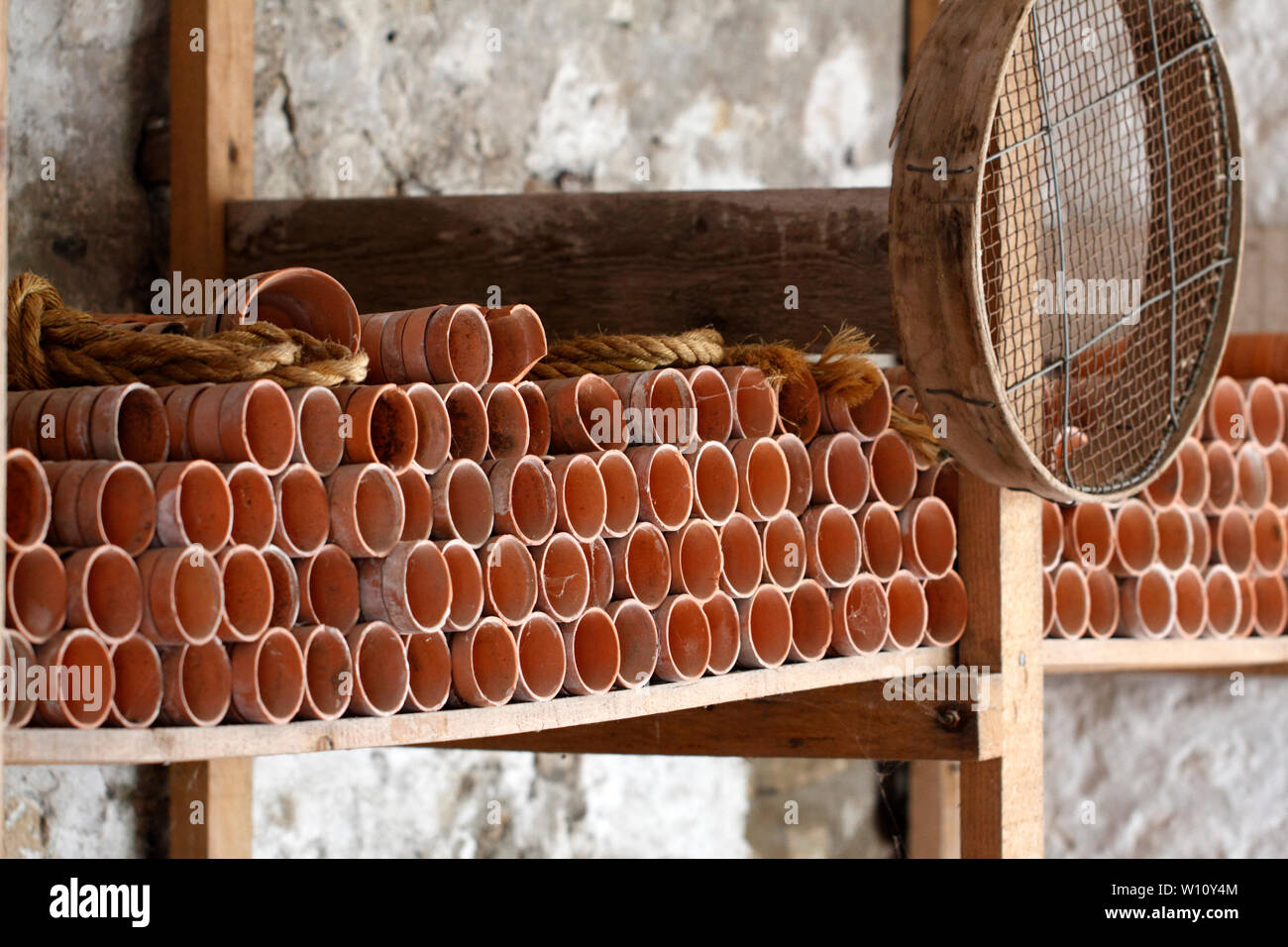 Pot store with a stack of clay pots on shelves Stock Photo - Alamy