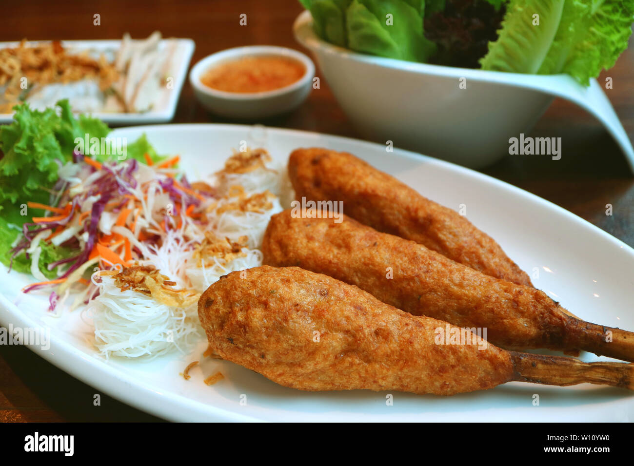 Plate of deep fried Vietnamese minced prawn wrapped around sugar cane