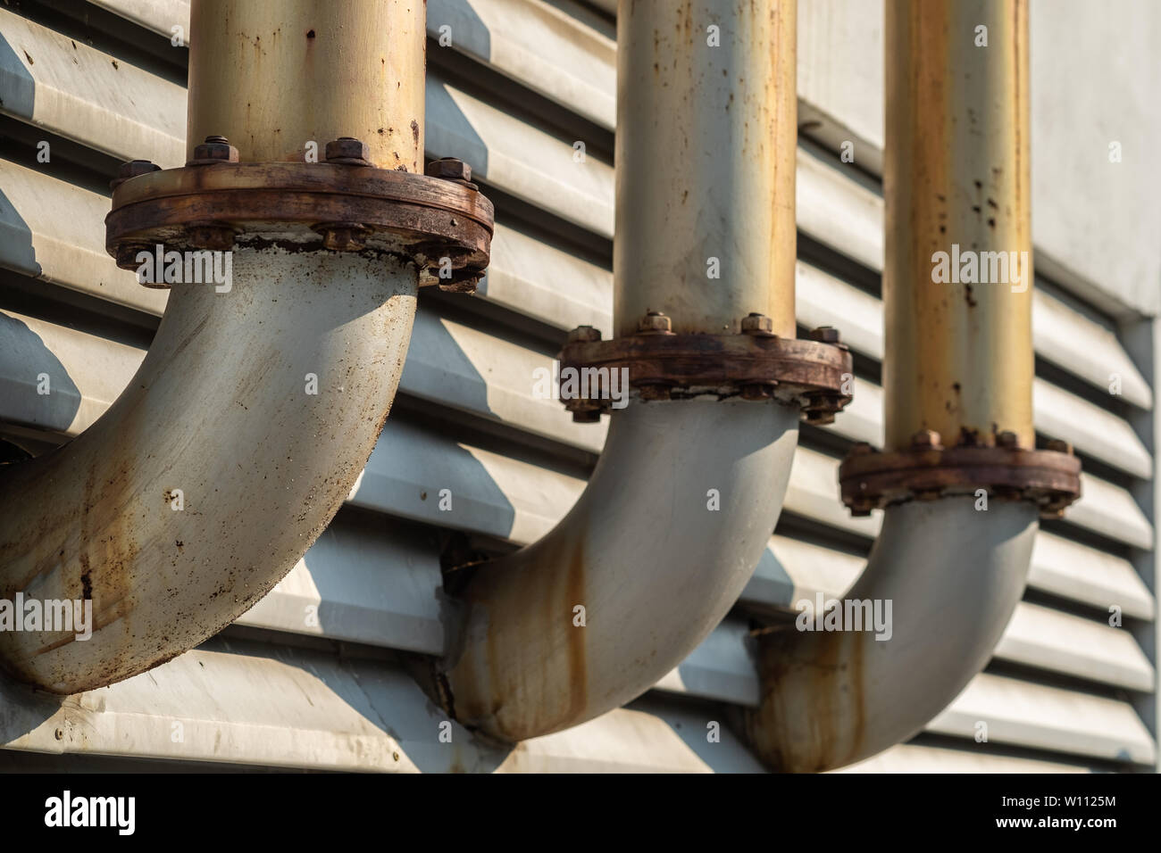 Connection point of the  three pipe ventilation ducts For venting smoke outside the building, rusty surface surrounding with sunlight and aluminium lo Stock Photo