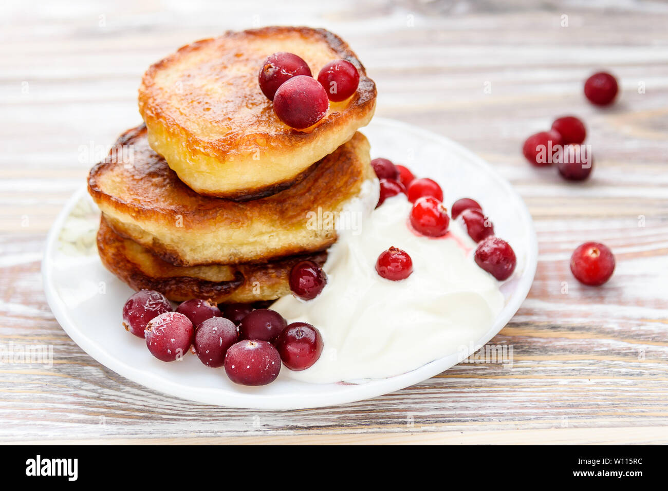 Pancakes with berries and sour cream on a plate. Summer cottage of Russian delicacies Stock Photo