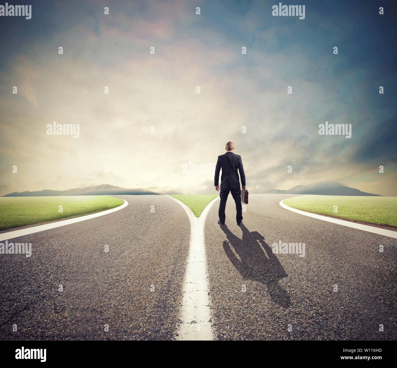 Businessman in front of a crossway must select the right way Stock Photo