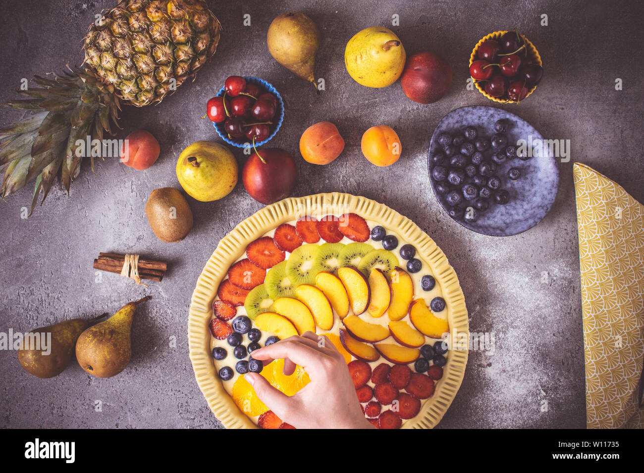 Female Hands Prepare Fruit Pie with Colorful Fruits and Fresh Dough. Healthy Food Concept. Stock Photo